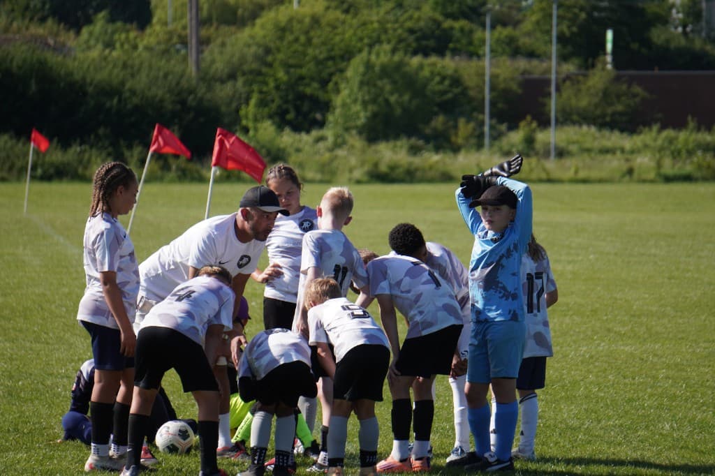 Youth football team huddle with coach
